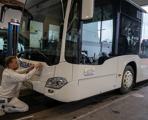 Ablauf einer Beschriftung an einem Reisebus.